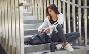 garota sentada em escada conferindo a mochila