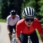 Mulher e homem pedalando e usando capacete de ciclismo