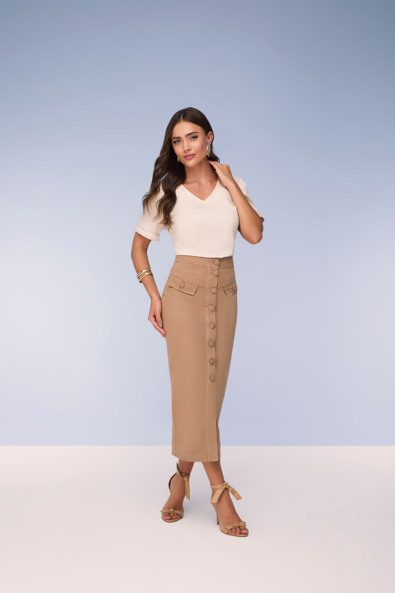 Modelo vestindo uma saia midi elegante em um cenário urbano luxuoso, demonstrando estilo casual chic.