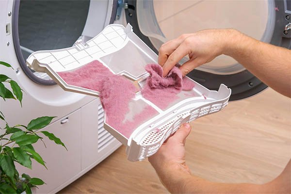 pessoas limpando o seu filtro da máquina de lavar para lavar as suas toalhas de banho
