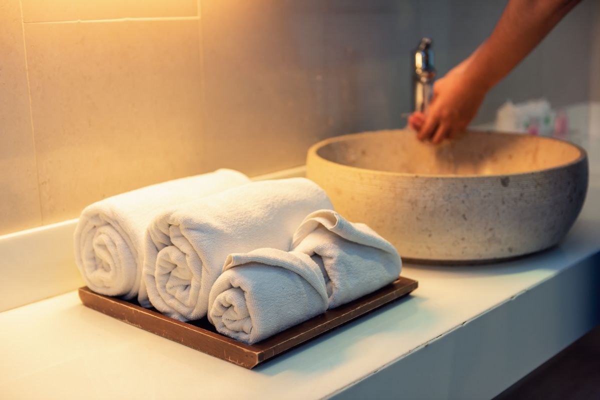 toalhas de banho em cima de balcao de banheiro