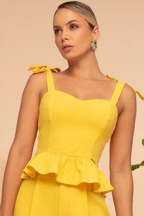 Bela dama de blusa branca contém um saco de palha e flores de laranja.  mulher bonita com roupa elegante leve segura bolsa de malha com buquê.