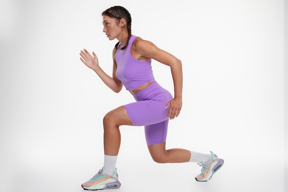 mulher se exercitando usando blusa e short fitness