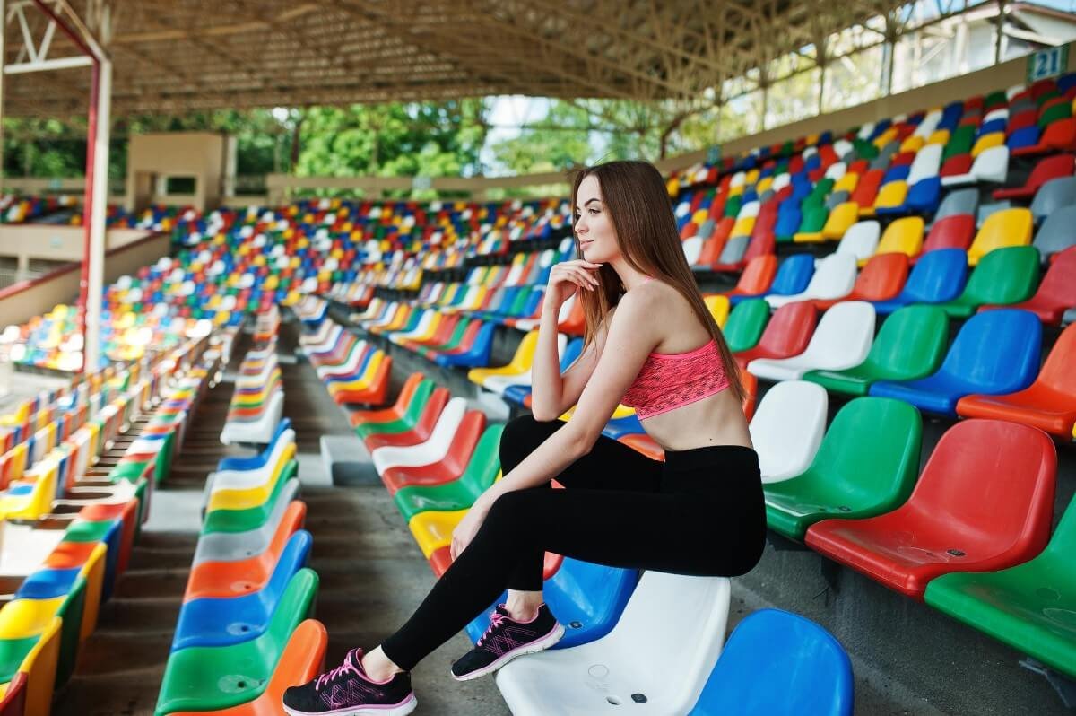 garota sentada em cadeira de estádio