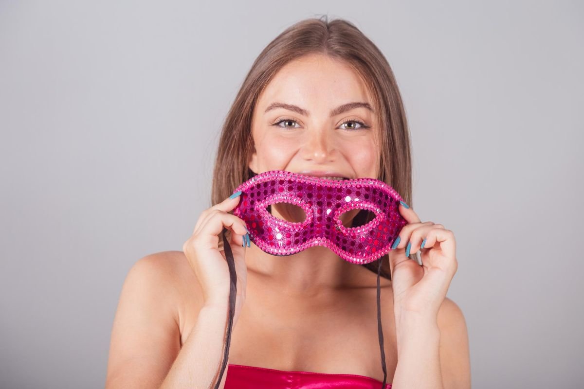 garota segurando máscara de carnaval