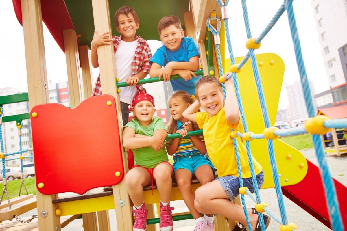 varias criancas usando conjuntos infantis se divertindo em playground