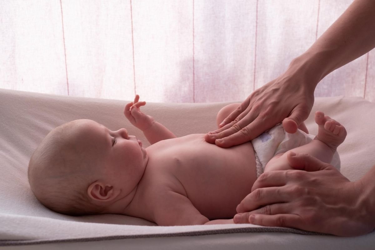fazendo massagem para aliviar a colica do bebe
