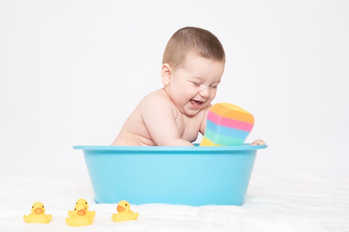 criança com brinquedos tomando banho de balde