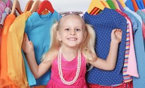 menina na frente de uma arara mostrando as cores na moda infantil