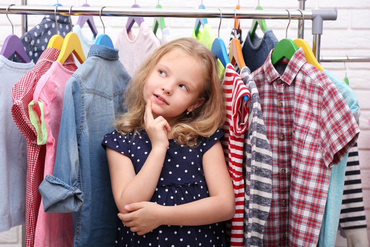 garotinha pensando em comprar roupas