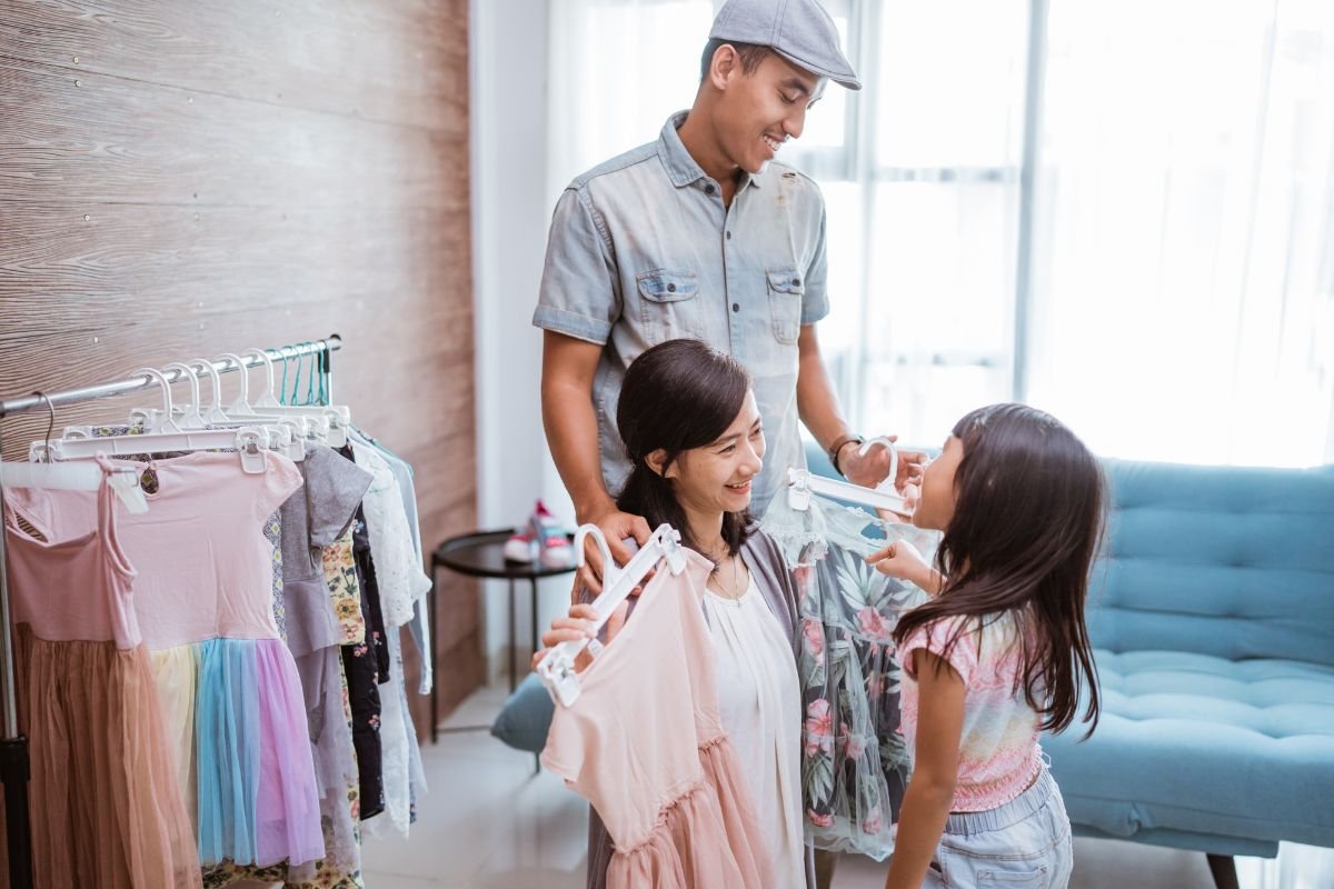 pais ajudando filha a escolher roupas