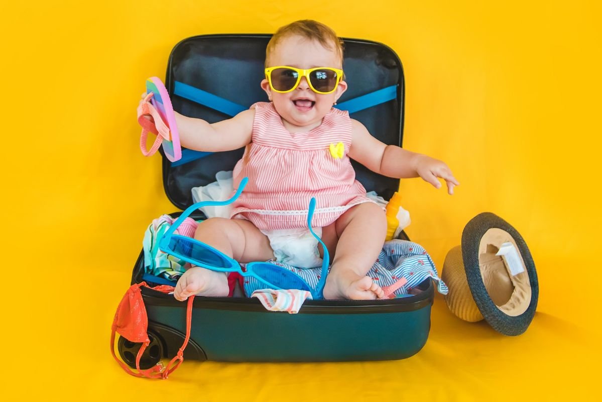 menina sentada em cima da mala do bebe