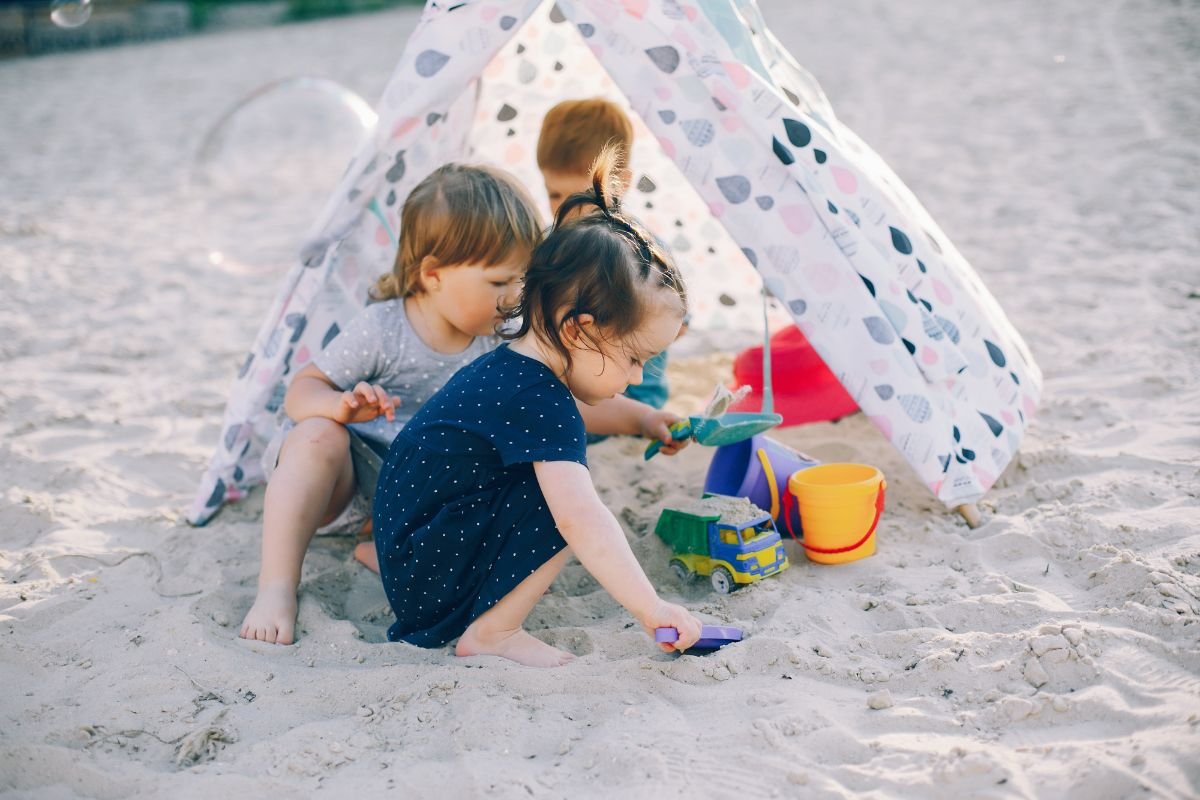criancas brincando na sombra em uma praia