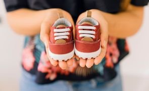 mãe segurando sapato infantil