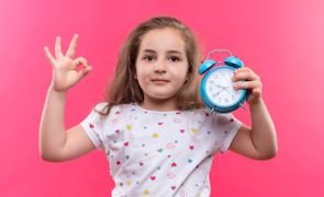 menina segurando relógio em sinal de ter uma rotina infantil