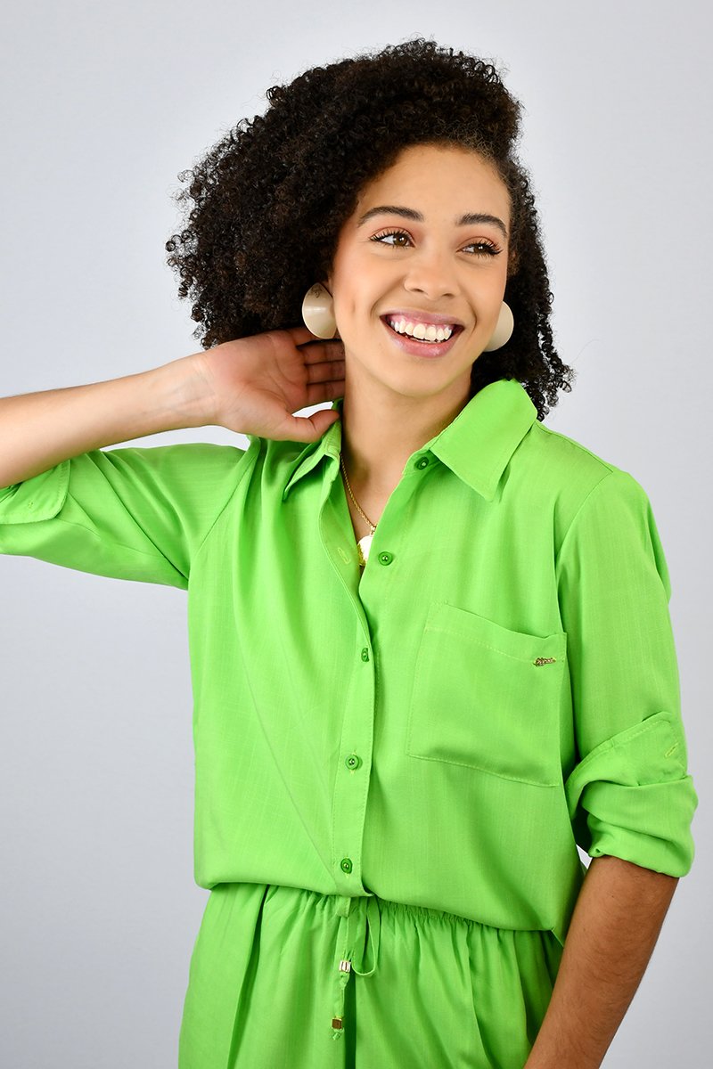 Uma roupa rosa e verde com uma saia verde e uma camisa branca com um laço  na frente.