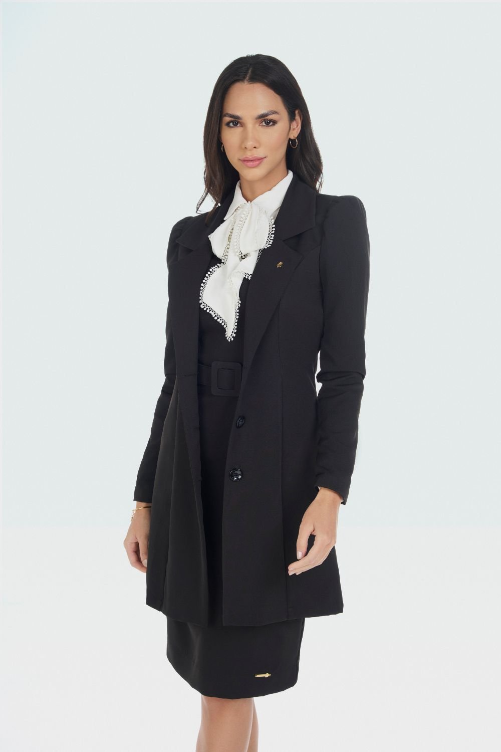 casaco de alfaiataria preto com vestido de alfaiataria preto e camisa branca com laço no pescoço